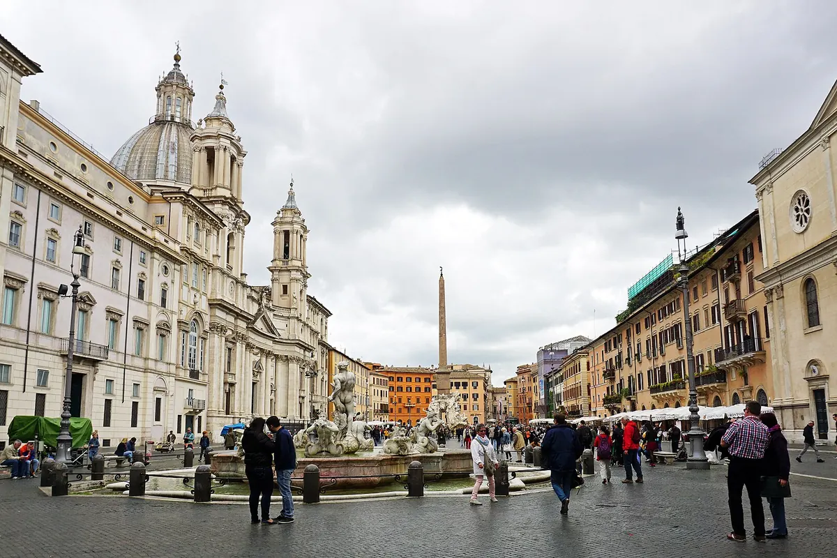 Piazza Navona på en grå dag, med Fontana del Moro i forgrunden, obelisken bagved og Sant'Agnese in Agone til venstre.